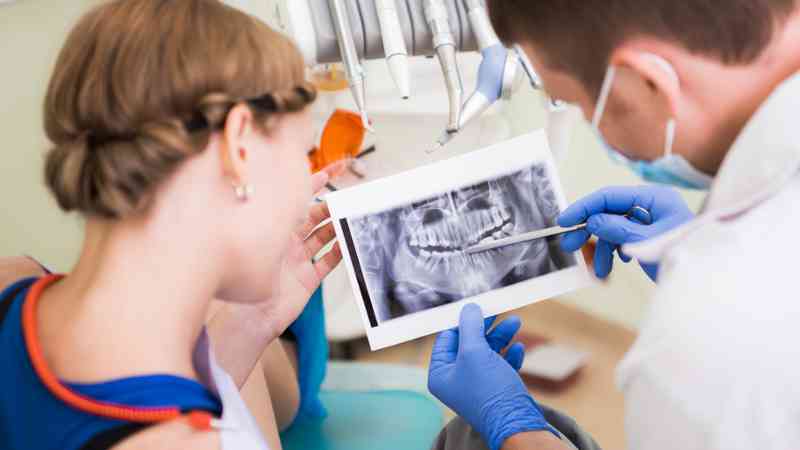 Dentist checking Xray for dental implant